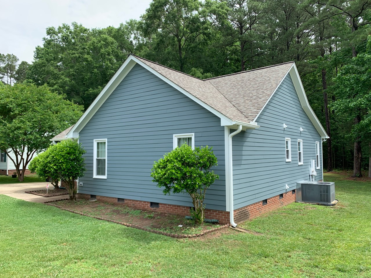 side view of a home after an exterior transformation. siding and roof replacement.