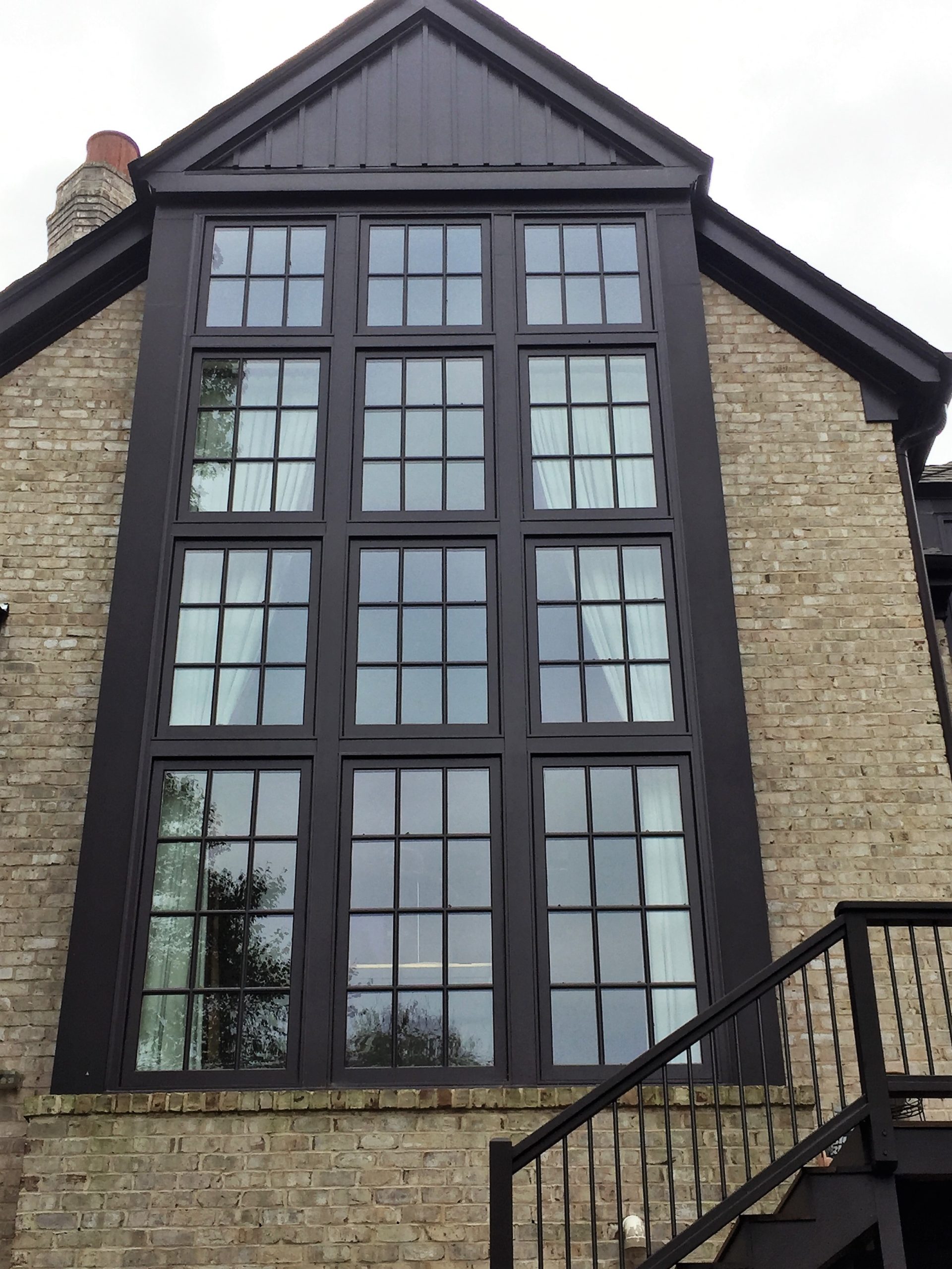 A striking brick building with expansive, black-framed windows—showcasing premium siding and windows in Raleigh & Apex, NC.
