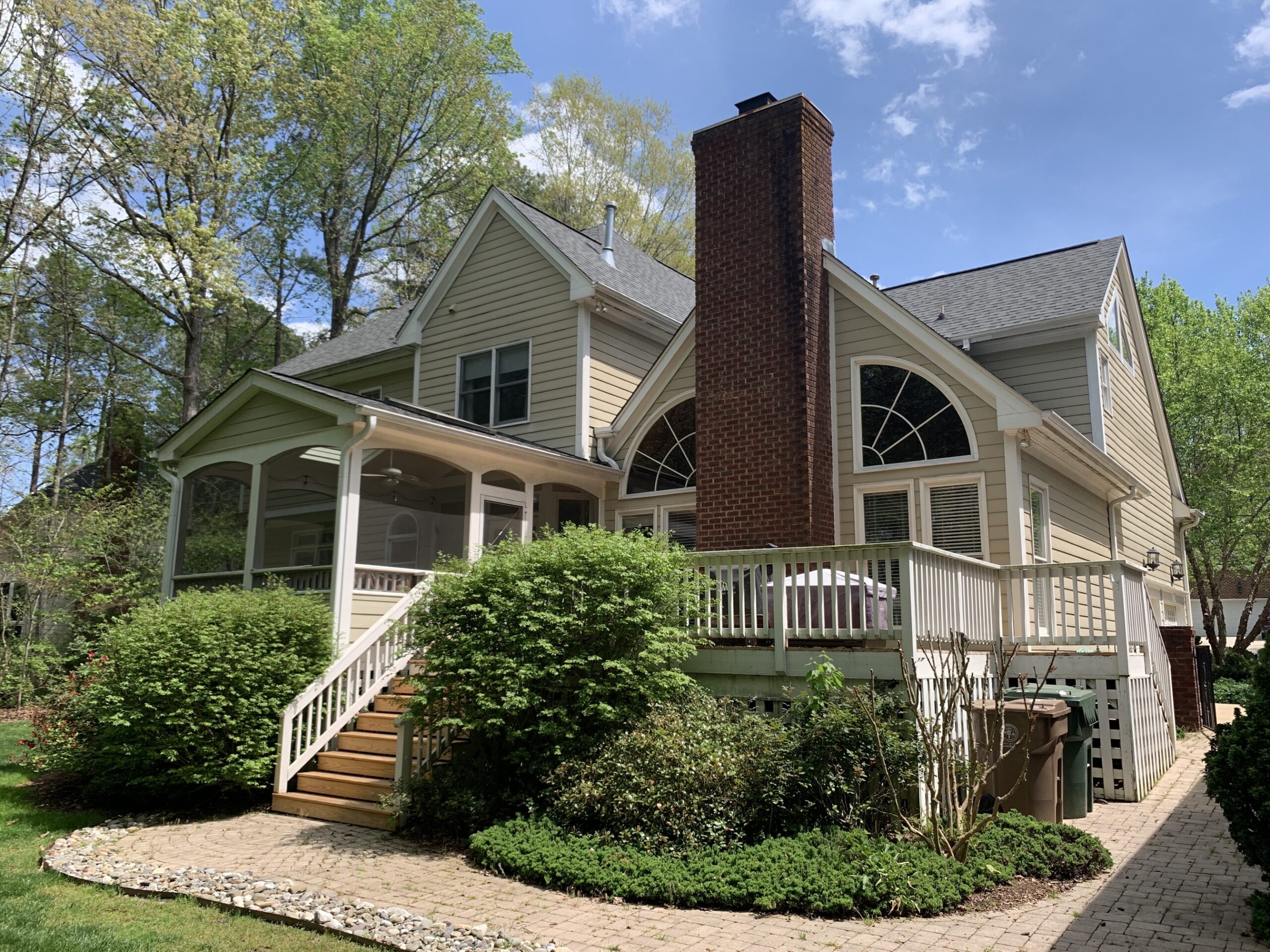 Different types of windows displayed n the backside of a two-story home. A window replacement in Durham improves your home's value.