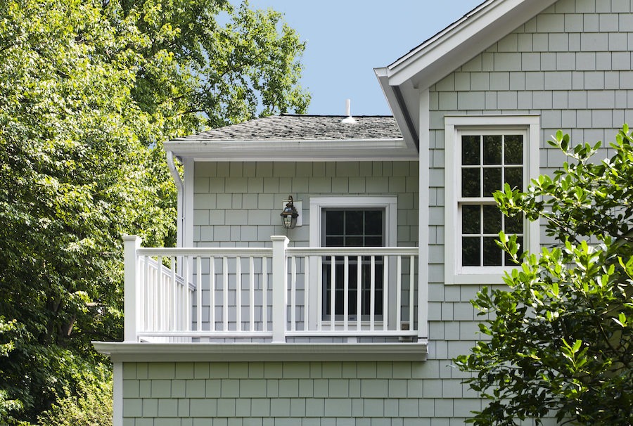 Light gray house with white trim siding, windows, and roof—perfect for Raleigh/Apex, NC. Trees & blue sky surround the home.