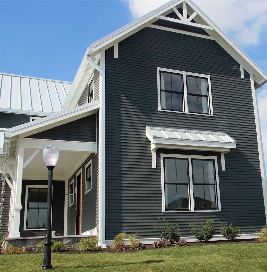 A two-story house with Carolina dark gray siding, white trim, black windows, and a metal roof—perfect for Raleigh & Apex, NC.