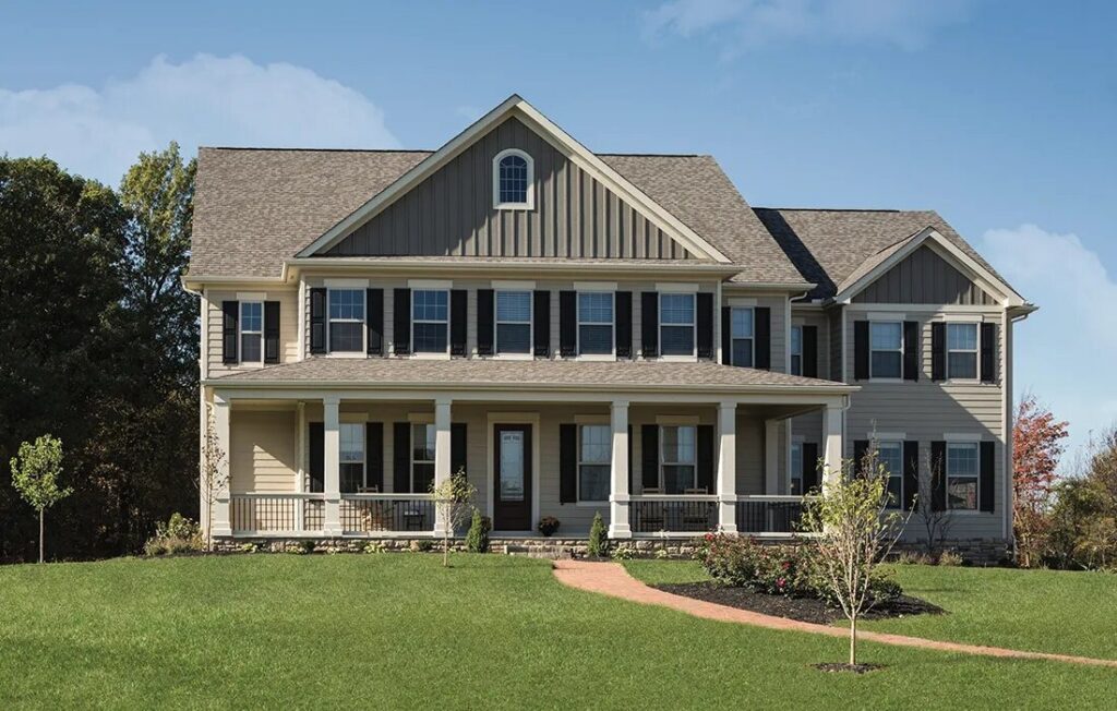 A two-story home with Carolina gray siding, white trim, and large windows in Raleigh, NC; gabled roof and covered porch.